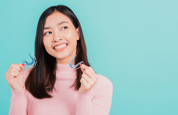 Lady holding retainers after braces